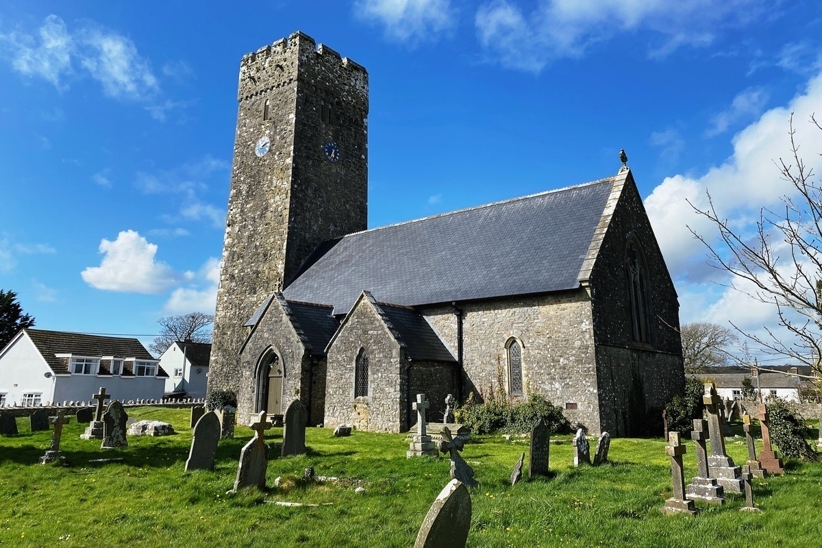 Stone churc with square tower, graveyard in foreground
