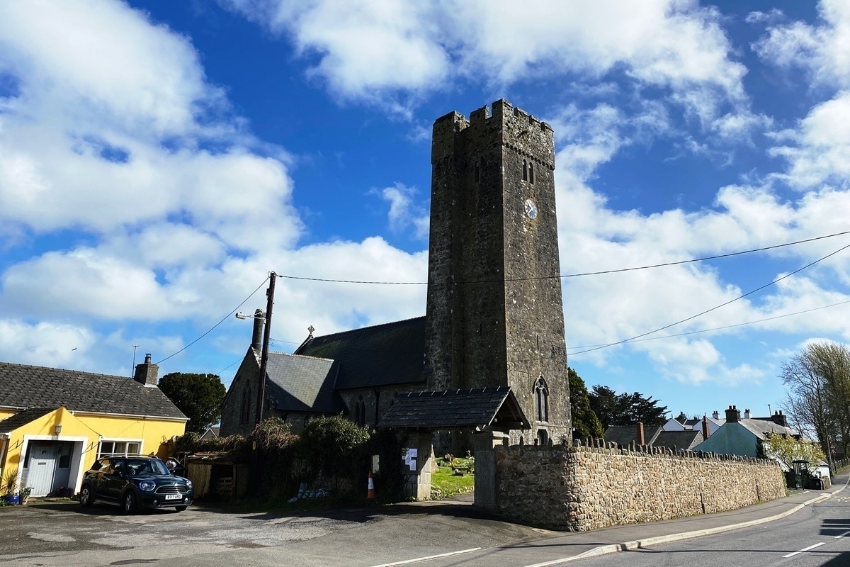 Stone church with square tower viewd from a road