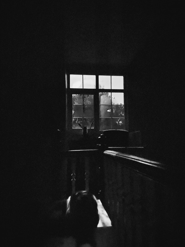 Window and landing darkly illuminated with moonlight