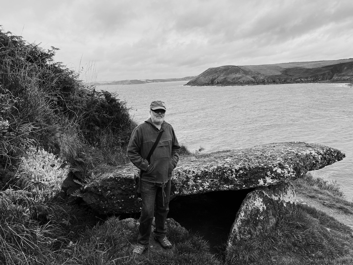 Ian Mason at King's Quoit Neolithic burial chamber overlooking Manorbier Bay