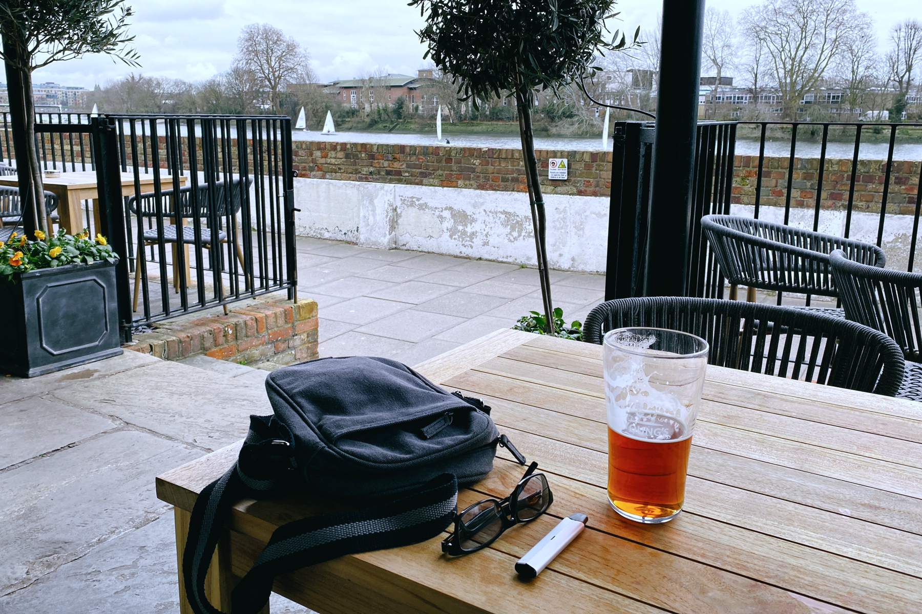 Pint of beer on a table, river in the background